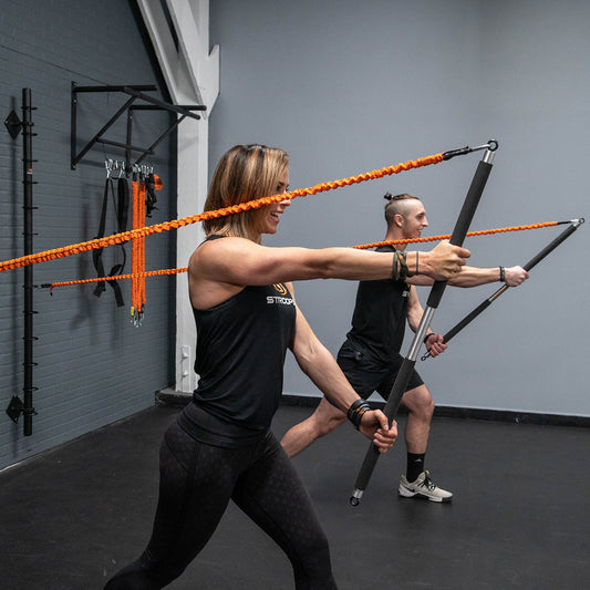 Two people using resistance bands in a gym setting
