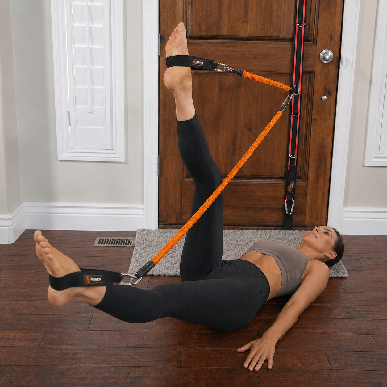 Woman performing pilates style movements on the floor with Stroops Slastix and spine strap