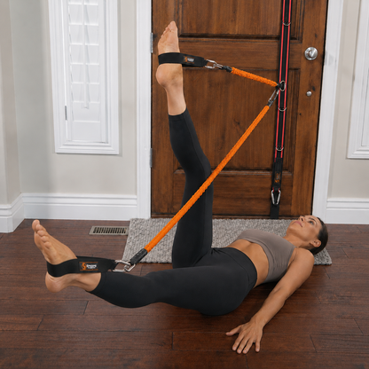 Woman performing pilates style movements on the floor with Stroops Slastix and spine strap