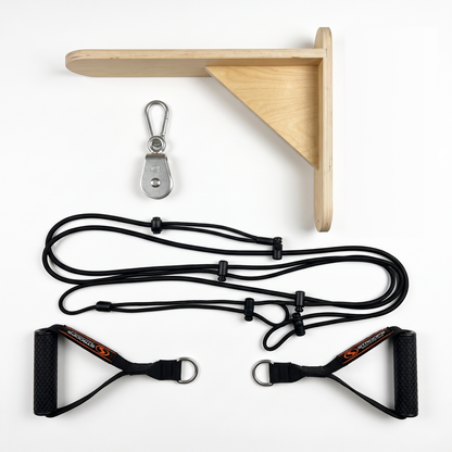 A wall-mounted resistance band set laid out on a white background, including a light wood corner bracket, a silver metal hook, black resistance cords, and two black handles with textured grips and red/orange branding.