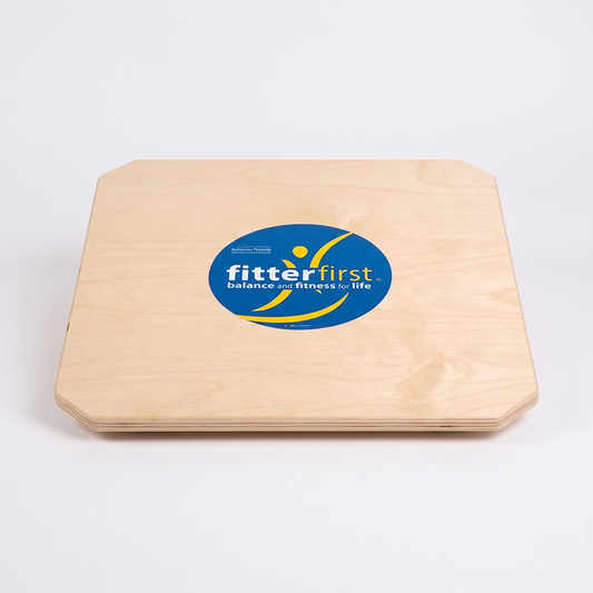 A square wooden balance board with rounded corners, featuring a blue circular 'fitterfirst' logo in the center, photographed on a clean white background.