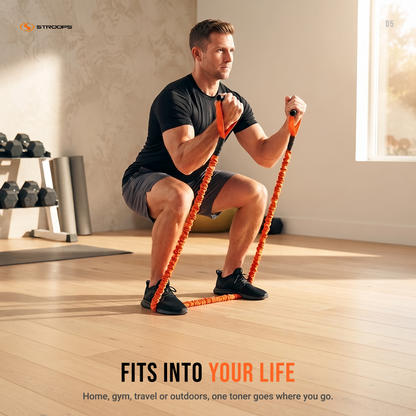 A man in a black t-shirt and gray shorts performs a squat while using an orange and black resistance band with handles in a bright, modern home gym. The STROOPS brand logo is visible in the top left, and promotional text is at the bottom.