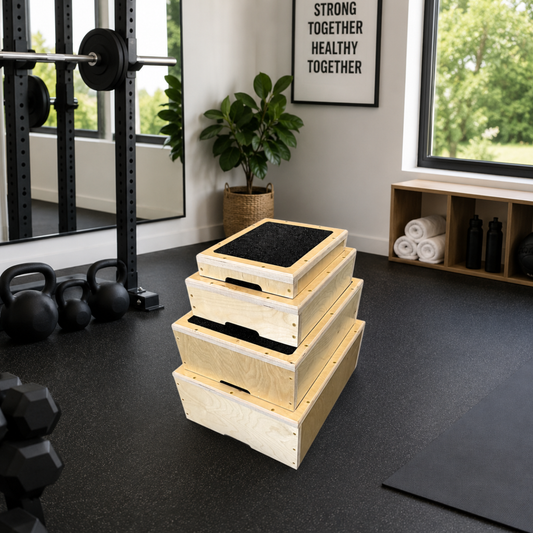 Stack of wooden step platforms in a gym setting with fitness equipment and motivational quote on the wall.
