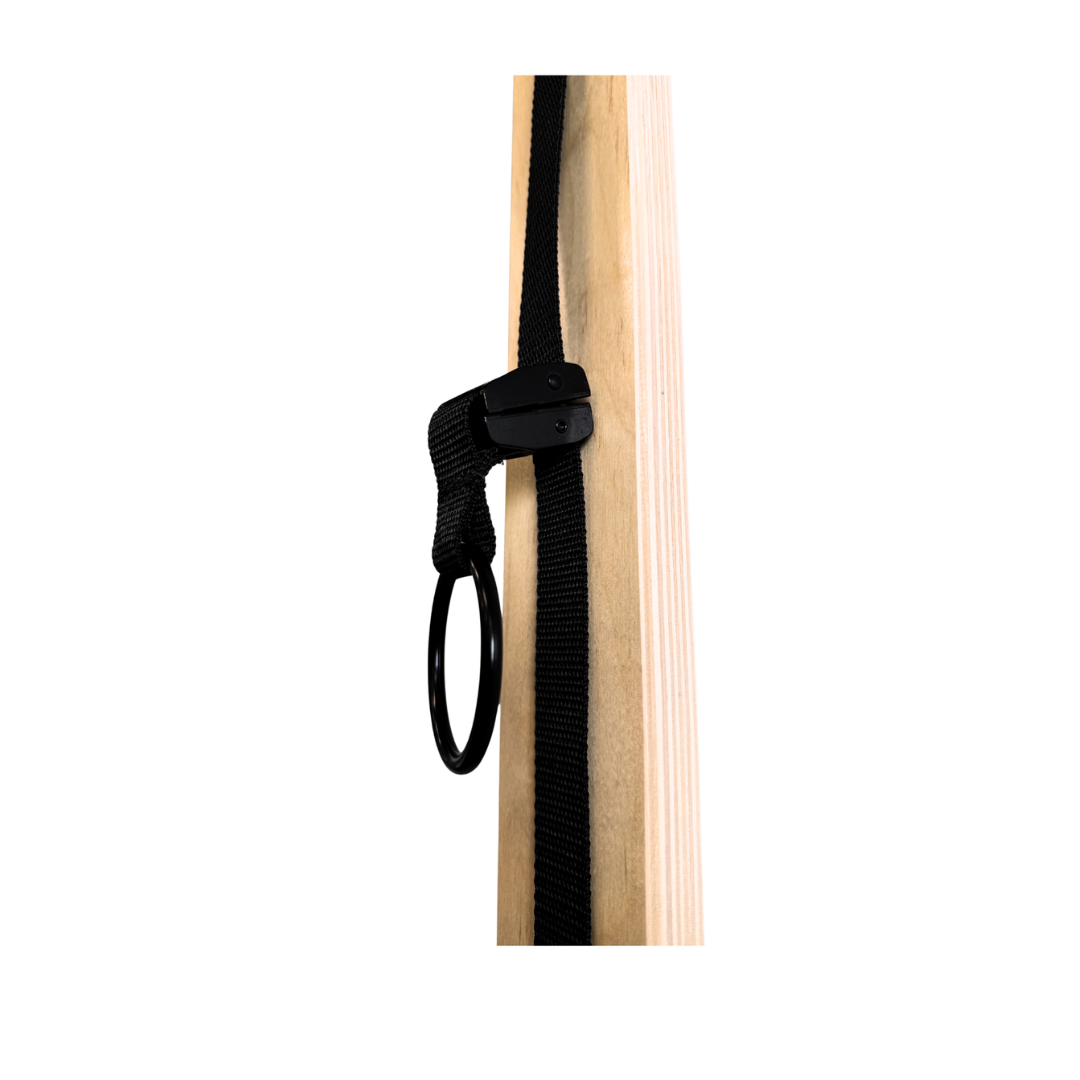 Black strap with a clip attached to a wooden surface on a white background