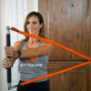 Stroops trainer Aly doing rotational strength exercise using Fit Stik and Slastix from a front view