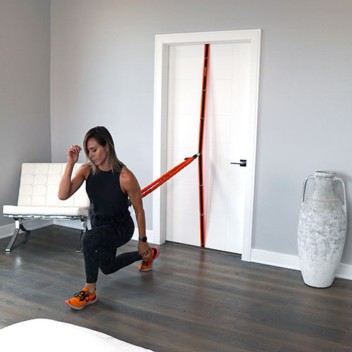 Stroops trainer Aly doing lunges using VITL, Spine Strap, and Universal Swivel Belt