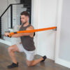 Stroops trainer James doing forward lunge with one arm press anchored to door anchor