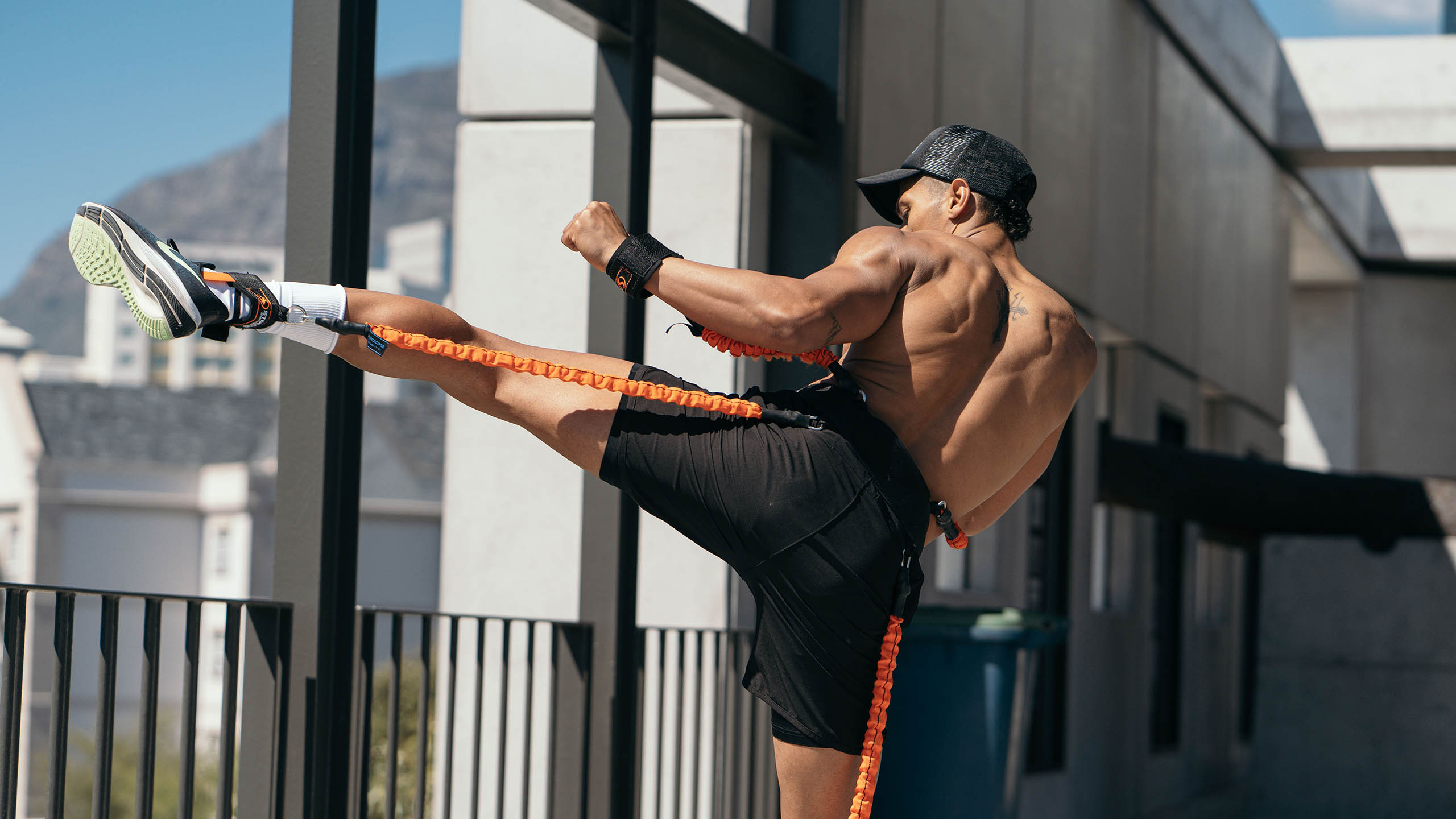 athletic man using the striker kit outside on a balcony