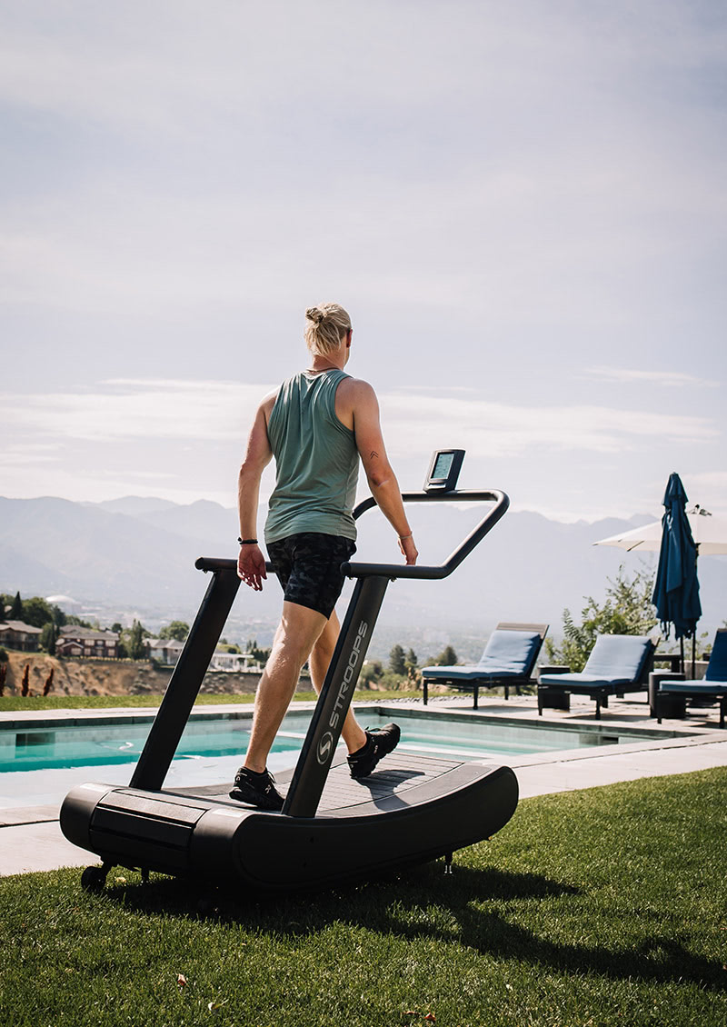 stroops athlete running on the opticurve treadmill outside