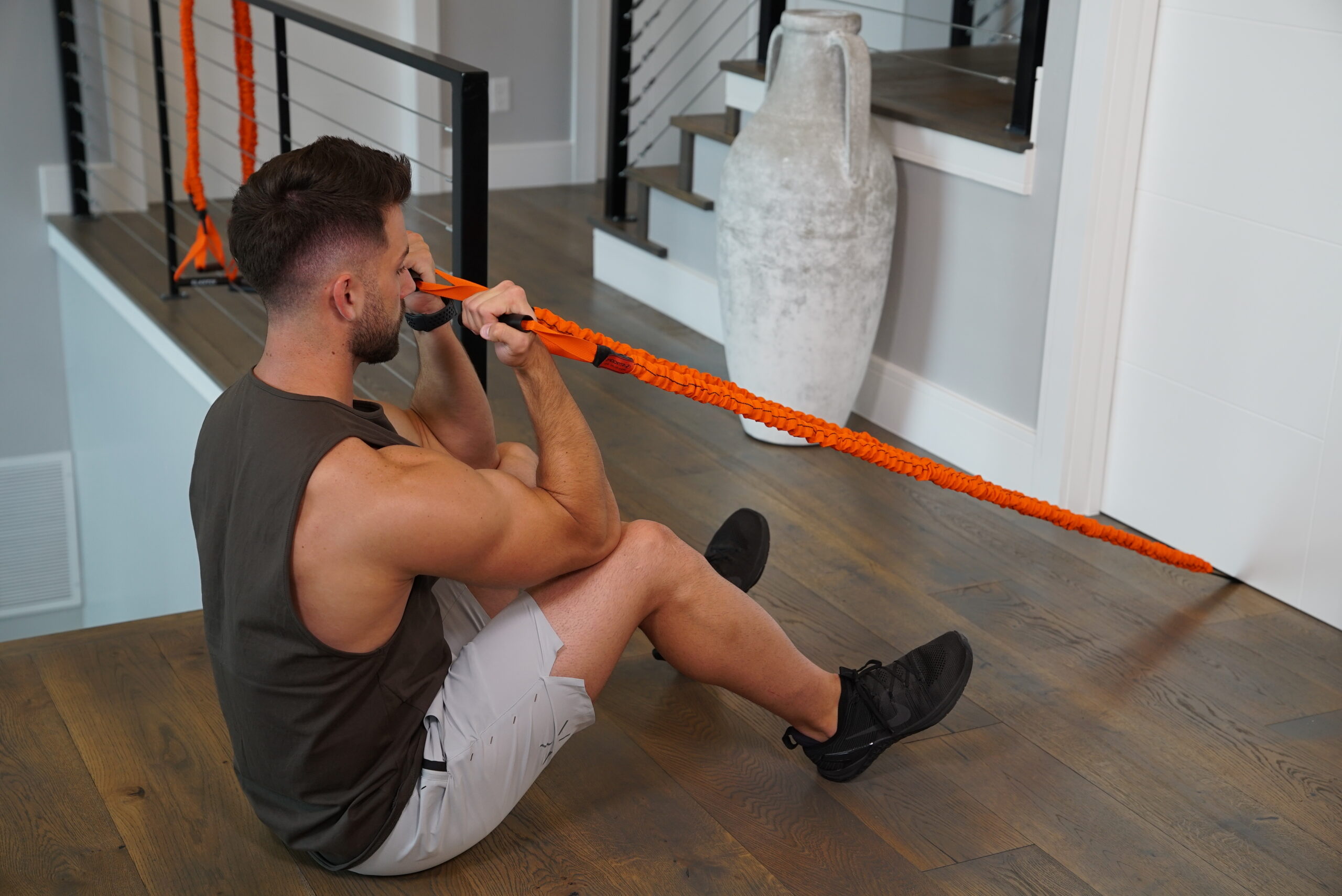Stroops trainer James performs a sitting bicep curl with resistance bands