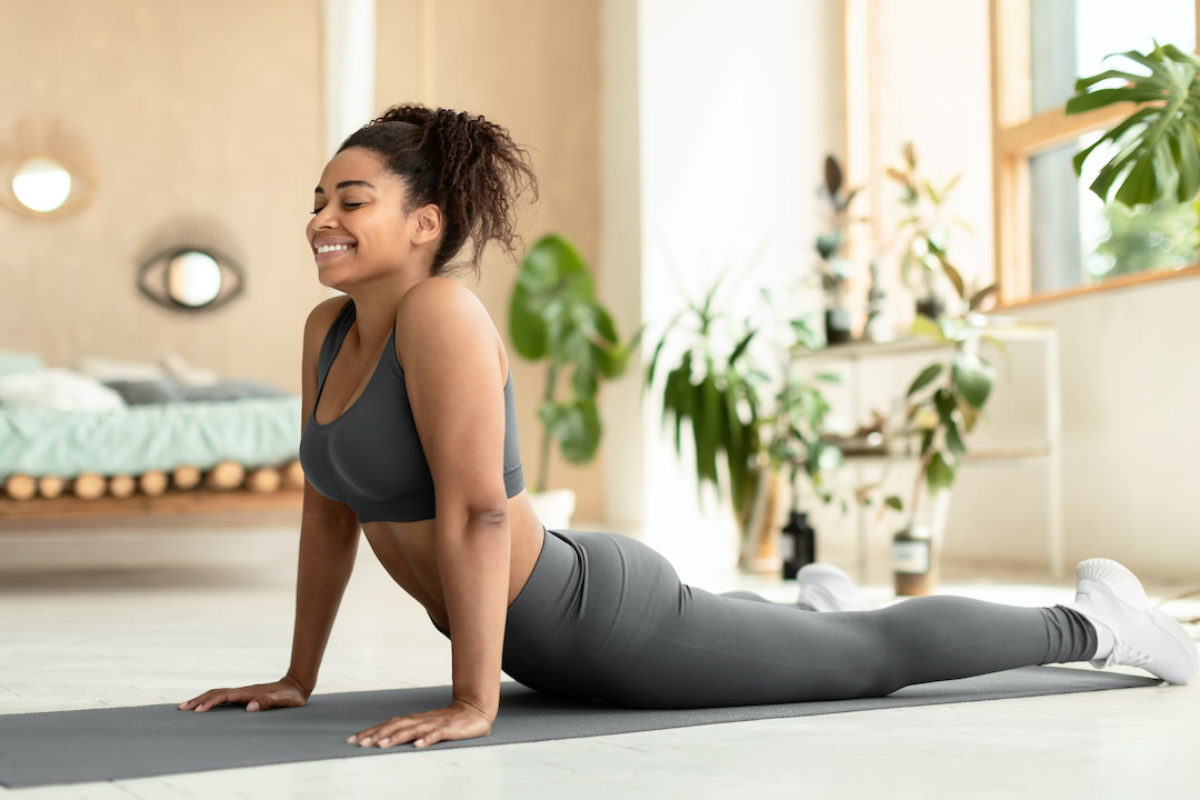 Woman doing cobra pose for yoga for back pain.