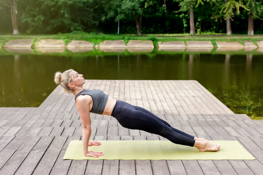 Woman athlete doing a reverse plank for full-body exercise.