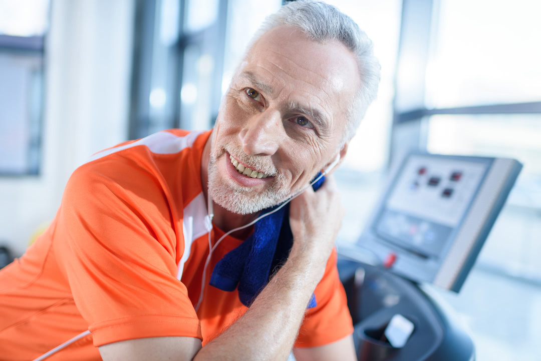 Older athlete using a gym towel